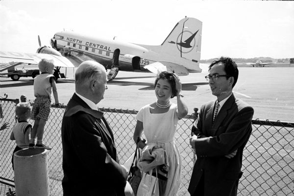 Rotary District 625's scholarship committee chairman Basil I. Peterson greets Japanese student Tomoko Arai at the Madison Municipal Airport. She will be studying social work under University of Wisconsin professor Virginia Franks on a Rotary scholarship. At right is Dr. Takuzo Ado, president of the University of Wisconsin Japanese Student Association.