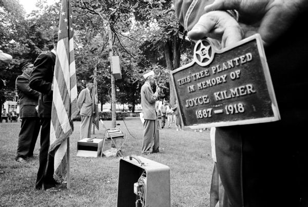 A plaque dedicating a tree in memory of Joyce Kilmer is placed on the State Capital grounds at a special ceremony held by the State Disabled American Veterans (DAV). A.J. Menard, Green Bay, holds the plaque. Menard served with the late poet in the "Fighting 69th" Division in World War I.