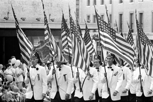 The Veteran Patrol of Zor Shrine marching in the ninth annual "Drums on Parade" around the Capitol Square while carrying American flags.