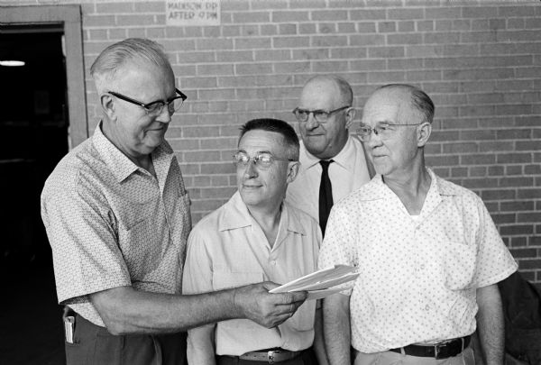 Dell Winters (left) presents gifts from fellow Post Office Department employees to three who are retiring. Retirees include, left to right: John McCullough, William Pulver, and Alfred Marks.