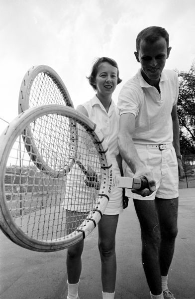 Jean and Harrison (Hatch) Echols posing while holding their tennis rackets. Individually and combined, they won five championship trophies at a city tennis tournament.