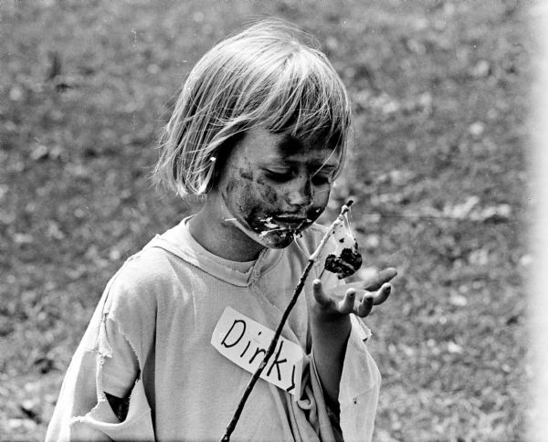 Soot-smudged Dorothy Phelan (3) eating a charcoal toasted marshmallow at the Wirth Ct. Park Hobo Party.