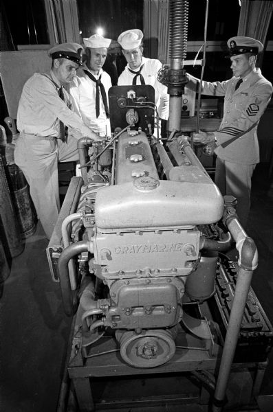 Navy reservists train at the Naval Training Center at Truax Field.
A diesel marine engine is checked over by reservists (L-R) Paul Ferguson, 1423 Spaight St.; Elmer J. Bram, 1001 High St.; Richard Herring, 5818 Thorstand St.; and Richard Nelson, 719 Jacobson Avenue.