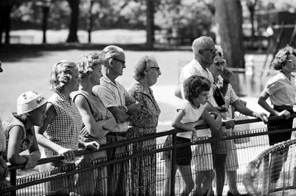 A group of people watching the animals at the Vilas Park Zoo, a popular summer pastime in Madison.