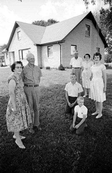 Brothers Edward and Oscar Saalsaa wed sisters Helen and Doris Andrews in 1942. They all lived together and farmed together. Doris and Oscar  Saalsaa (left) and Edward and Helen Saalsaa (right) and their children, Mary, 15, John, 18, and David, 9. They are posing in front of their new brick house that had six bedrooms and two bathrooms.