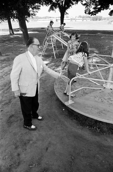 Joseph (Roundy) Coughlin is shown trying to get on board a new whirl-a-round at Children's Park at Central Wisconsin Colony and Training School. The new play equipment was purchased by money from "Roundy's Fun Fund."