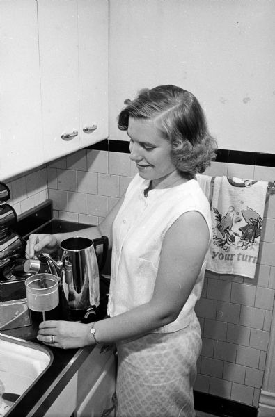 Newlywed Marilyn Mielke is shown in the kitchen preparing coffee in the new percolator that she and her husband, James, received as a wedding gift.