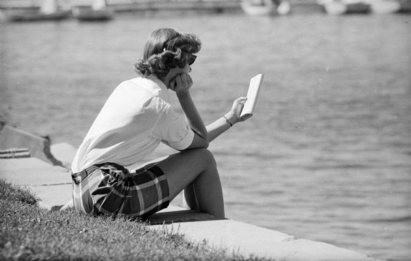 Sue Marsden, a freshman from Rockford, Illinois, is reading on a terrace overlooking Lake Mendota.