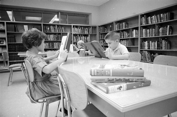 Third graders read in Blessed Sacrament school library. Left to right:  Mary Jo Sweeney, Kathy Gorman and Bill Morgan.