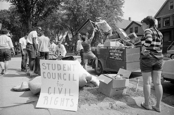 A group of students from the University of Wisconsin Student Council on Civil Rights picket a house on 540 West Mifflin Street and help to move out the possessions of a couple who had been evicted by the landlord because they temporarily sublet their apartment to a Negro couple.  The renter, Carl D. Weiner, and his wife were out of state and gave permission to University of Wisconsin economic instructor Marshall Hall, and his wife to stay in their apartment until their own apartment was ready. On their first night there, the Halls, natives of  Jamaica, British West Indies, were told by the landlord that they had to leave.