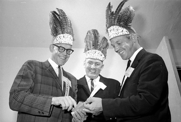 The Madison Chamber of Commerce's Tamasha event is held, including a golf tournament and an evening banquet with an Indian motif and entertainment, at the Maple Bluff Country Club. Shown (L-R) are William Schultz, executive director of the Madison YMCA; James Stanford, Wisconsin Telephone Co.; and Francis Hoffman, general manager of the Hoffman Enterprises.