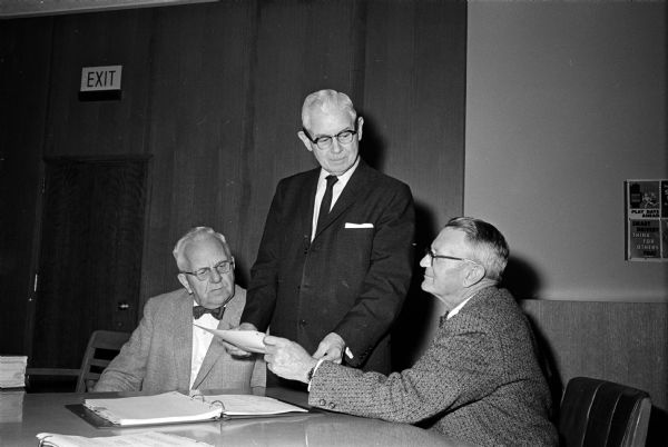 Superior Court Judge Roy H. Proctor, center, discusses his final budget proposal with Secretary Arthur C. Nelson, left, and County Board Finance committee chairman John Fluckiger.