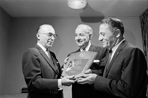 Madison attorney Maurice B. Pasch, center, is presented a plaque for community service by the B'nai B'rith lodge. Presenting the award are Harry Epstein, left, past grand president of the lodge's district, and Meyer Zimmerman, right, president of the Madison chapter.