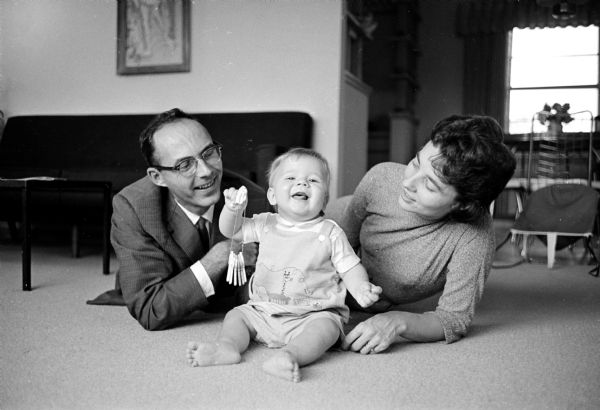 Timothy and Helen Matthews with their seven month old adopted son, Timothy John. They adopted their child through the Catholic Welfare bureau, a Red Feather agency.