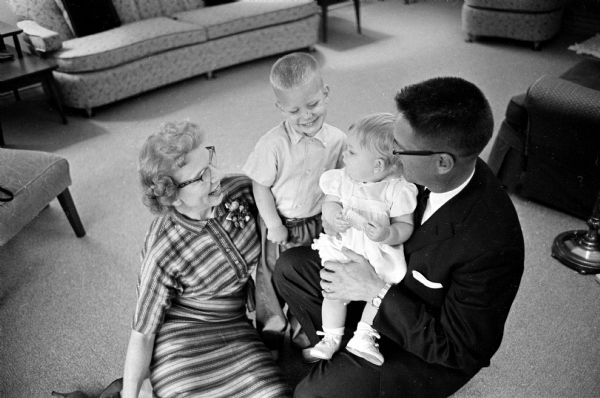 Dean and Betty Colden with their two adopted children; David, age three years and one year old Sally. The couple adopted their children through the Children's Service Society, a Red Feather agency.