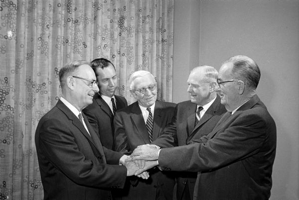 Former Wisconsin Governor Oscar Rennebohm, center, is the guest of honor of a banquet at the Wisconsin Center. Shaking hands with him are left to right: William Kleinheinz, a University of Wisconsin classmate; Charles Dahl, president of the Wisconsin Pharmaceutical Assn.; Carl E. Steiges, president of the U.W. Board of Regents; and Harry Leonard, another classmate of Rennebohm's.