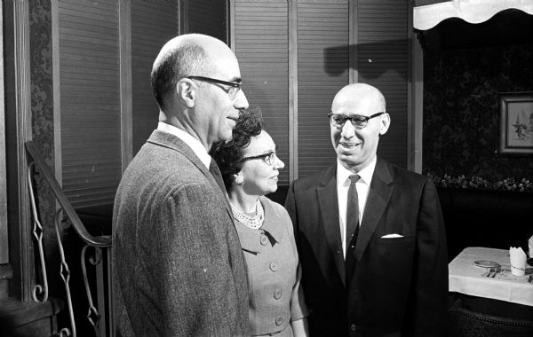 On the right is Henry J. O'Leary, who is being honored for his service as chief of the rates and research division of the state Public Service Commission. On the left is his successor, Orville P. Deuel. Mrs. Henry O'Leary is at center.