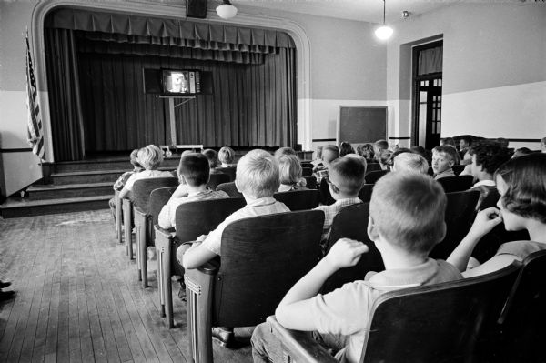 A conversation French class, "Parlons Francais," is shown on TV for 15 minutes twice a week to numerous Madison junior high school and grade school students. Fourth and fifth grade students at Lowell School are watching the show in the school auditorium.
