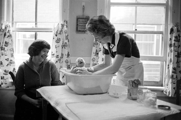 Visiting Nurses is one of 29 United Givers agencies. It provides free instruction about caring for infants, skilled home-nursing and part-time nursing care. Here a visiting nurse demonstrates to a mother how to bathe three-week-old baby Cornelia.