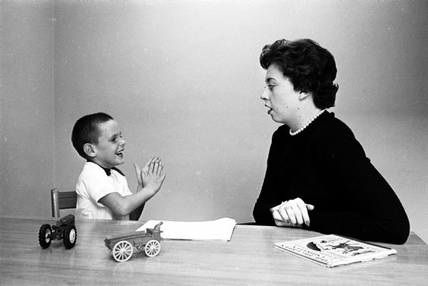 The Speech and Hearing Rehabilitation Center on the University of Wisconsin Campus is one of 29 United Givers agencies. It serves about 500 people each year providing help to infants, the deaf, the hard of hearing and others with vocal handicaps. Here a speech therapist helps a young boy create sounds.