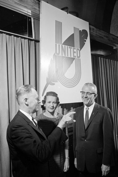 L.J. Larson, left, general chairman of the United Givers fund drive, signals to Jane Scrivner, co-chairman of the woman's division, and Francis Holford, president of the Community Chest, that the fund is at 96% of goal.