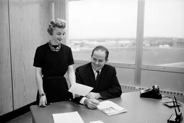 Certified professional secretary Ruth Breeden confering with John T. Hitt, general manager of CUMBIS Insurance Society, Inc.