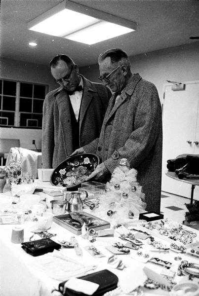 Edward Persen, left, and M. Earl Moore, 717 Pickford Street, looking at the items in the "white elephant" booth at the Harvest Festival, Grace Episcopal Church, 6 North Carroll Street.