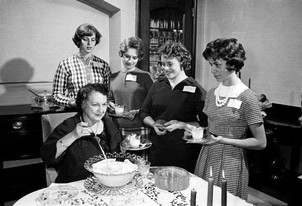 Mrs. Conrad Elvehjem, 130 North Prospect Avenue, wife of the president of the University of Wisconsin, was hostess for a tea to honor co-eds who are employed and unable to attend many of the university social functions. Left to right are: Eloise Fisher, Randolph; Nancy Willis, Fond du Lac; Allie Poehlman, New London and Nancy Steele, Milwaukee.