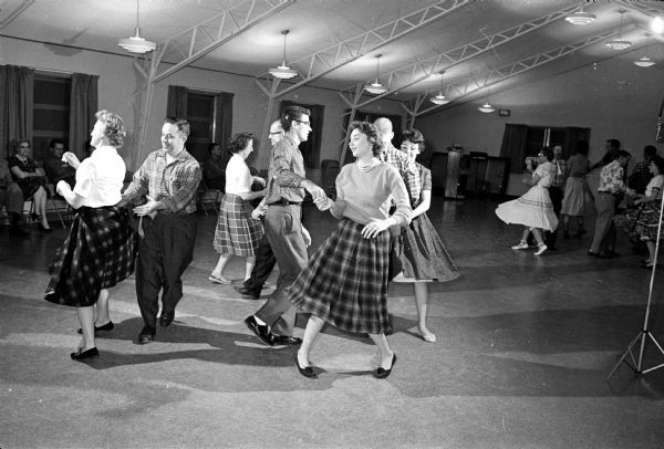 Members of the Madison Area Square Dance Council practice for the 11th annual "Doll Dance" held at Monona Grove School to gather dolls and stuffed toys for the Wisconsin State Journal's Empty Stocking Club. Hosts for the dance are members of the Boots and Slip-ers Square Dance Club.