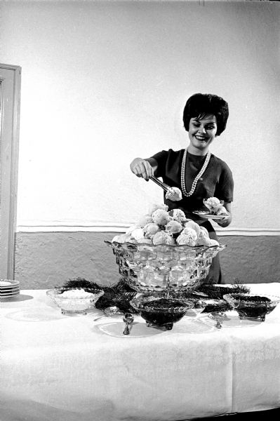 Carol Bradley, Chicago, serving a dessert of ice cream balls at the Ann Emery Hall "Tasting Tea" at 265 Langdon Street.