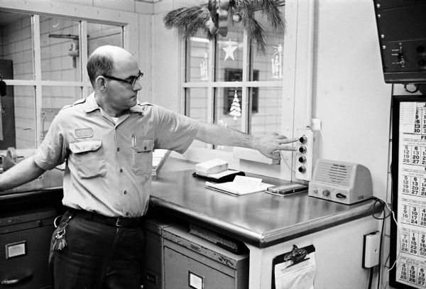Jailer Ralph Chesemore examining the control room buttons that were pushed to unlock a series of doors leading to the Dane County Jail lobby in an unsuccessful attempt to escape. William Welter and Lawrence Nutley were in solitary confinement after being accused of slaying a policeman in Lake Delton in August.