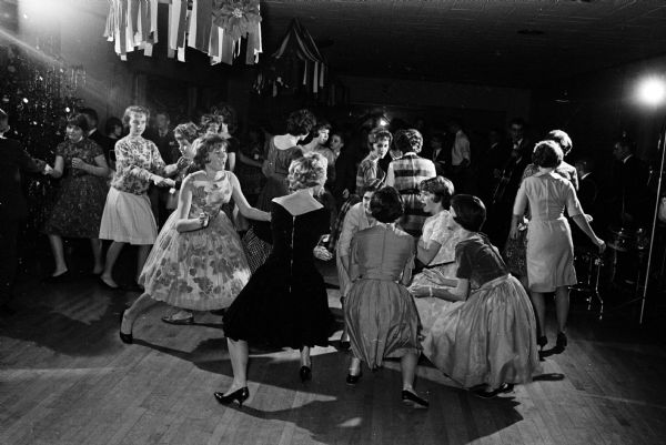 Teen-age girls dancing the twist at the annual Shorewood Hills teen-age dancing party. The six girls in the foreground are, left to right: Barbara Washburn, Marta Holmgren, Cheryl Topp (face partially concealed), Nancy Krasno (back to camera), Betsy Irwin, and Ellen Burns.