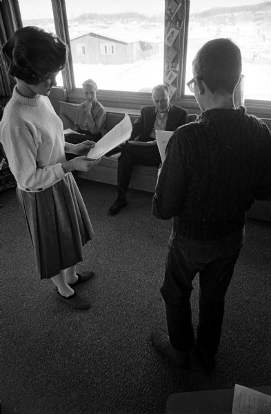 Debbie Holmes and Nick Plakies read from Prof. Jerry McNeely's script with Wally Ogden and Prof. McNeely, University of Wisconsin professor of radio and TV, looking on.