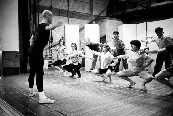 Visiting choreographer William Burdick, in navy blue tights, rehearsing six U.W. dancers for the play "The Servant of Two Masters." The dancers, pictured left to right, are Marilyn Scott, Jennifer Warren, Lisa Henstrom, and Anita Murray. In the back row are John Wilson and Harvey Robbin. Burdick was a solo dancer and choreographer for the Metropolitan Opera Co. and a teacher at the Institute for Advanced Study in Theater Arts in New York City.
