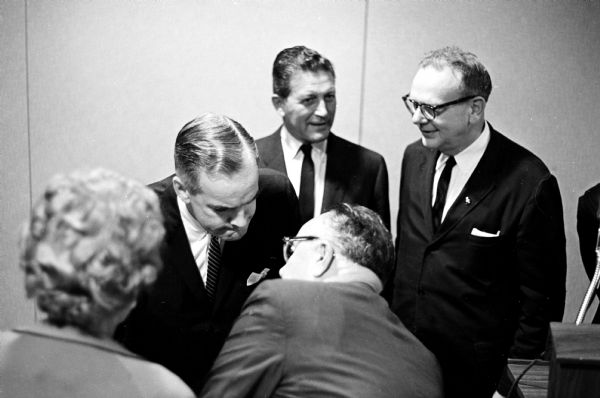 Gov. Matthew Welsh of Indiana (left) shown interrupting his conversation with two other governors to whisper to one of his aides at the Democratic Midwest Conference held at the Park Motor Inn. The other two governors are Otto Kerner of Illinois (center) and John W. Reynolds of Wisconsin (right).