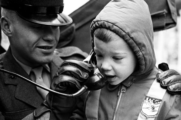 Marine James Tetzlaff of the Marine Corps Reserve helping Mike Lehnherr, age 3 of Verona, put his short wave call through to the North Pole at Westgate Shopping Center. The men of the reserve corps set up the high-power radio equipment at several locations and encouraged parents to contribute to the <i>Wisconsin State Journal</i> Empty Stocking Fund.