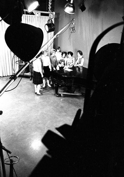 Nine eighth grade girls rehearsing for the long television benefit for the Empty Stocking Fund at WISC-TV, co-sponsored by the <I>Wisconsin State Journal</I>. The girls are from the Nichols Nuggets, a 4-H group of Madison's Nichols School area.
