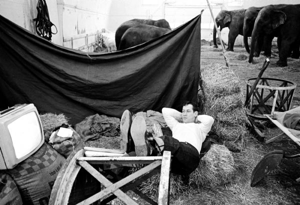 Gary Rupp of Farmington, Michigan, an aide to the bear trainer for the William Kay Shrine Circus, relaxing after finishing chores for the opening of the circus sponsored by the Zor Temple of Madison.
