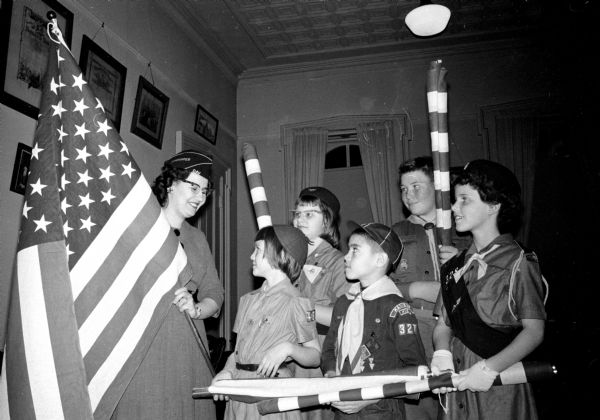 Audrey Doll (left), commander of the ladies of the Disabled American Veterans (DAV) auxiliary, is shown presenting five flags to scout troops in Madison. Representing their Scout units were: front row left to right, Jan Sweeney of Marquette Brownie Troop 48; and Howard Garcia, Lakeview Pack 327. Back row, left to right: Susan Graham, Glendale Troop 89; Robert Wellner, Mendota School Troop 23; and Mary Anne Fass, Blessed Sacrament Troop 328.