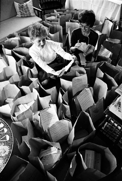 Nancy Kupchan and Marieli Rowe check packages of flyers telling about Madison's unique Children's Festival, sponsored by the Wisconsin Association of the American Council for Better Broadcasts, to be held at the Wisconsin Union Theater. It is only one of its kind in the country.