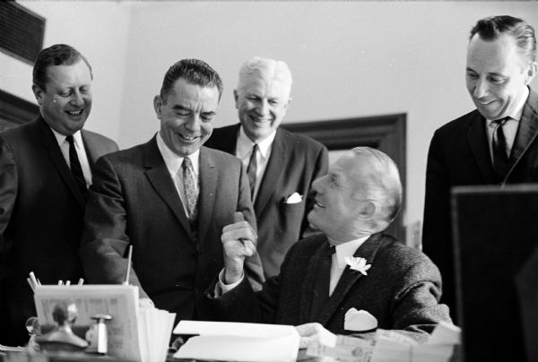 Representative John W. Byrnes, Green Bay, standing, second from left, is shown as he is presenting to Secretary of State Robert Zimmerman, sitting, a certified slate of delegate candidates to the Republican National Convention. Looking on is Talbot Peterson, left, state GOP chairman and George Greely, executive secretary of the Wisconsin GOP.