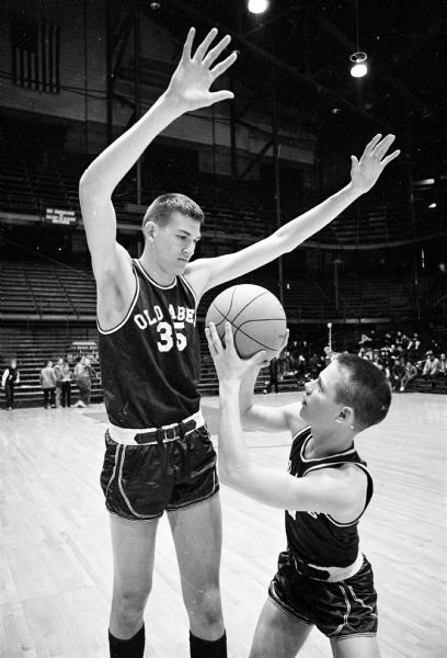 Eau Claire Memorial High School basketball players, (L) Loehnis (6'9") and (R) Elliott (5'7"), prepare for a state tournament game.