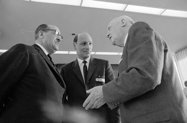 Scandinavian trade delegation of 25 Norwegian businessmen and journalists visit Madison to publicize the inaugural flight of Scandinavian Airlines System (SAS) direct service from Copenhagen to Chicago. Shown (L-R) are delegates Clifton Wharton, and Erik Himle talking to E.B. Fred, U.W. President.