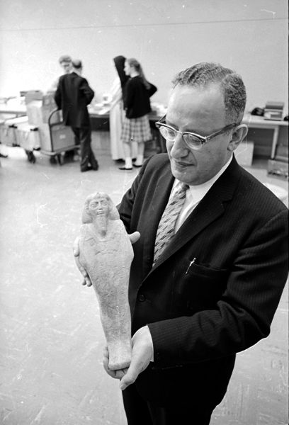 Professor Menahem Mansoor holding an ancient Egyptian figurine to be part of "The Book and the Spade" Biblical artifacts exhibit at the Wisconsin Center.