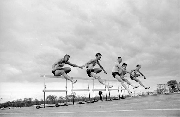 U.W. track athlete Gene Dix (third from left) sets a meet and track record in the 120 yard high hurdle event in a dual meet with Minnesota.