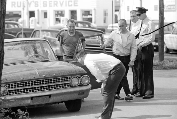 A safety-conscious motorist has his car checked at one of the two stations set up in Madison as part of a voluntary vehicle safety checkup program.  Location is on Brearly Street near the intersection with East Washington Ave.