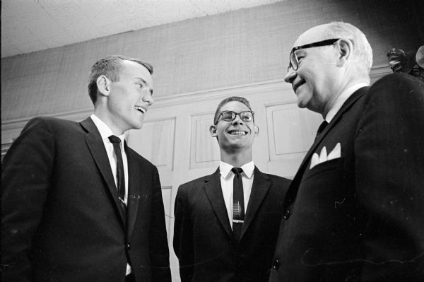 On the right is Lawrence H. Fitzpatrick, managing editor of the Wisconsin State Journal, and two high school students to whom he presented the 1964 Madison Newspapers, Inc, scholarship awards of $250 each. The students are, left to right: Alan Genz, La Follette High and Michael Sherman, Belmont High.