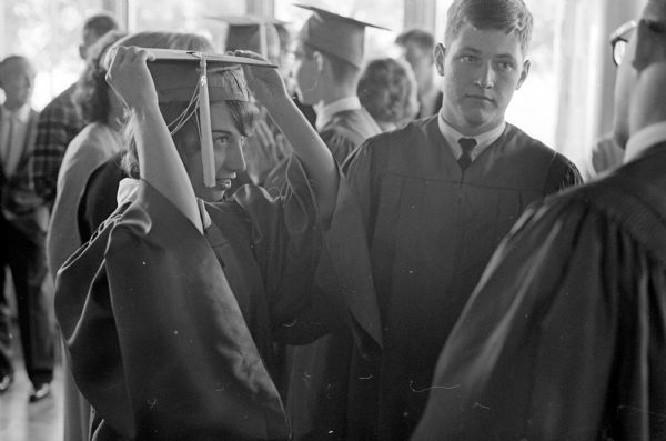 A scene from the final commencement of Wisconsin High School. Students are wearing gowns and caps and preparing for the graduation ceremony.