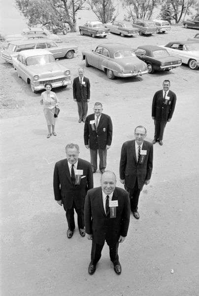 Officers of the University of Wisconsin Alumni Association are shown standing at the site of the future Alumni House, 650 N. Lake Street.
Show clockwise from the bottom are Dr. Robert Spitzer, Burlington, President; Anthony G. DeLorenzo, Detroit, First Vice-President; Charles O. Newling, Chicago, Chairman of the Board; Kate D. Huber, Indianapolis, Secretary; Robert J. Wilson, Madison, Treasurer; Arlie Mucks, Jr., Madison, Executive Director; and James Voughan, Cedar Rapids, IA., Second Vice-President.