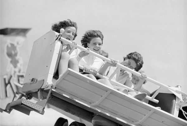 Three girls on the "Flying Coaster" carnival ride at the ESBMA festival on Kid's Day.